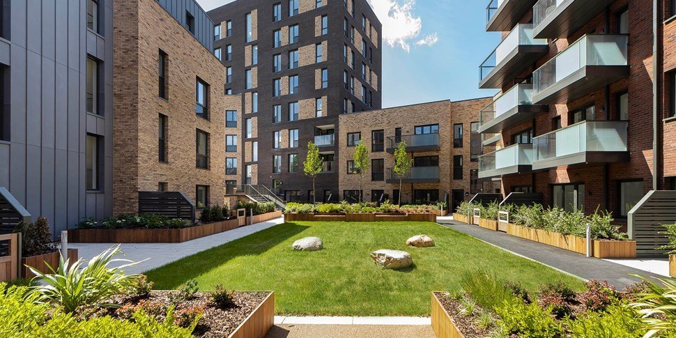 A modern apartment block courtyard with rows of similar flats