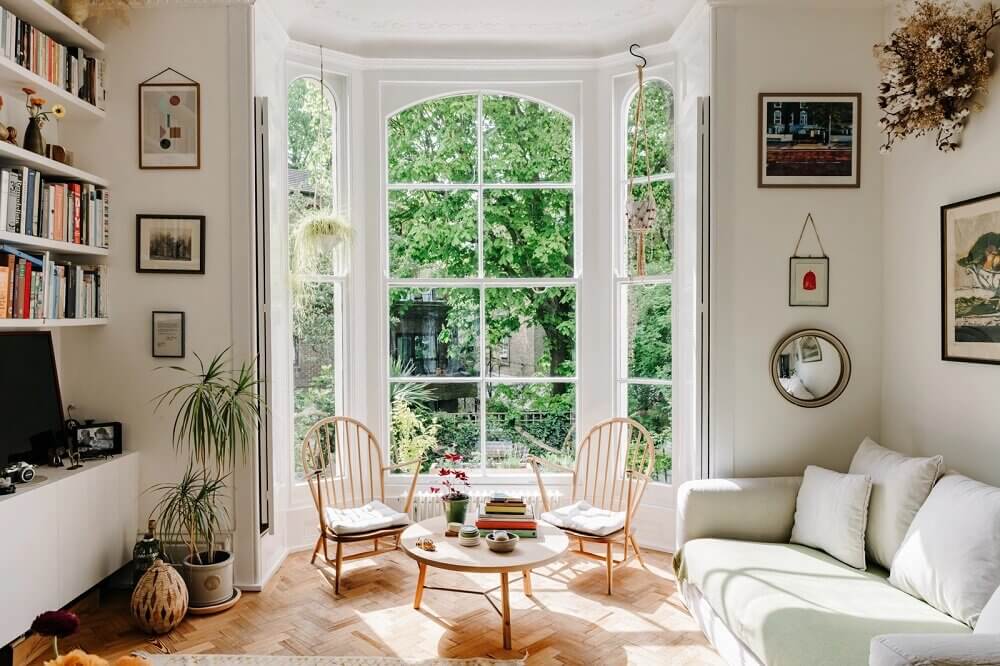 A bright living room with a bay window and garden view